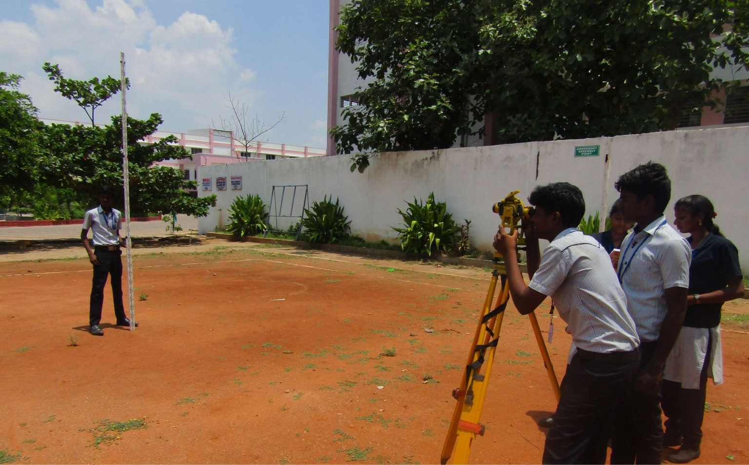 Civil students surveying with a theodolite
